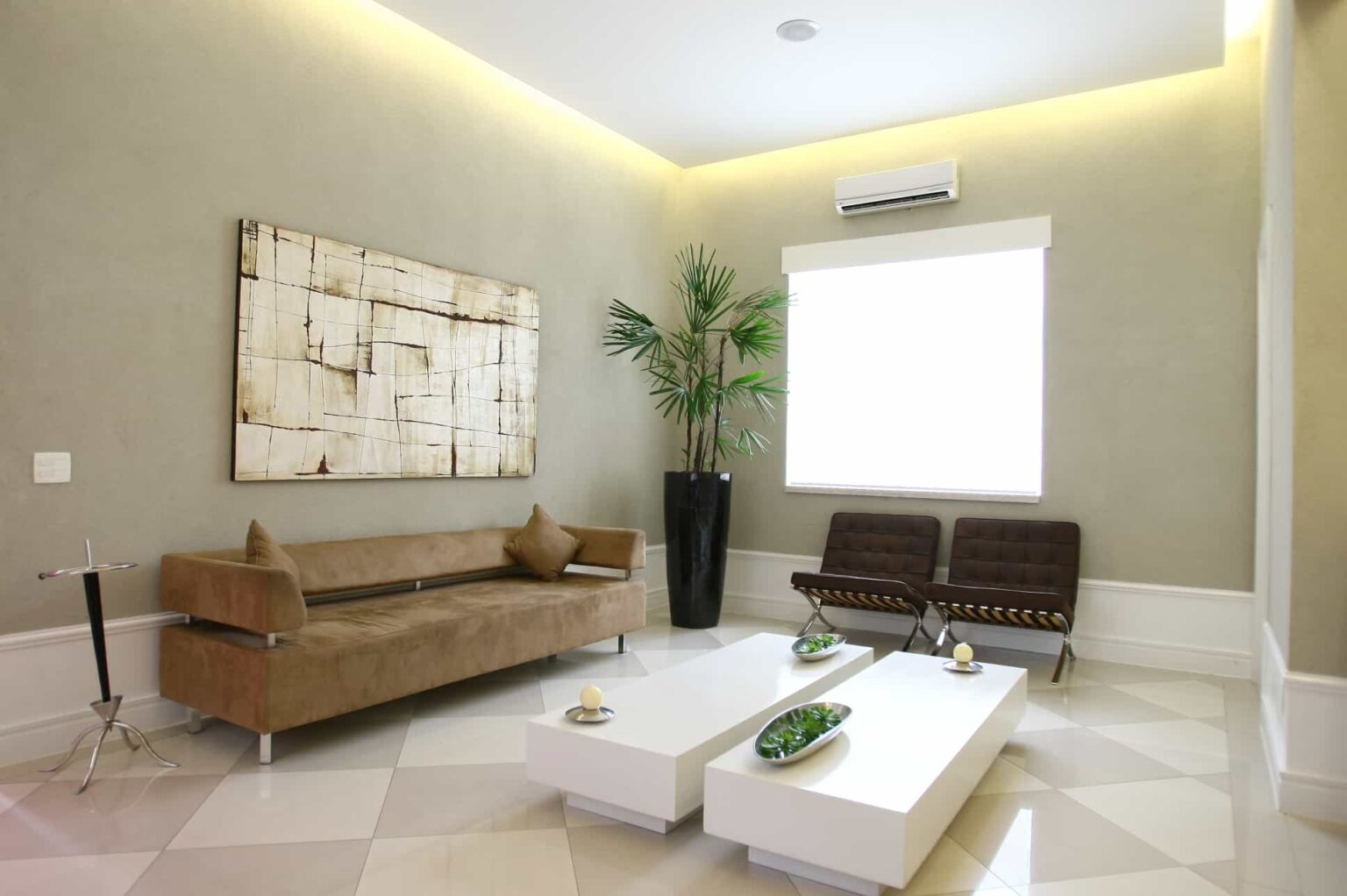 Ambiente climatizado de sala de espera, com sofá e assentos aconchegantes
